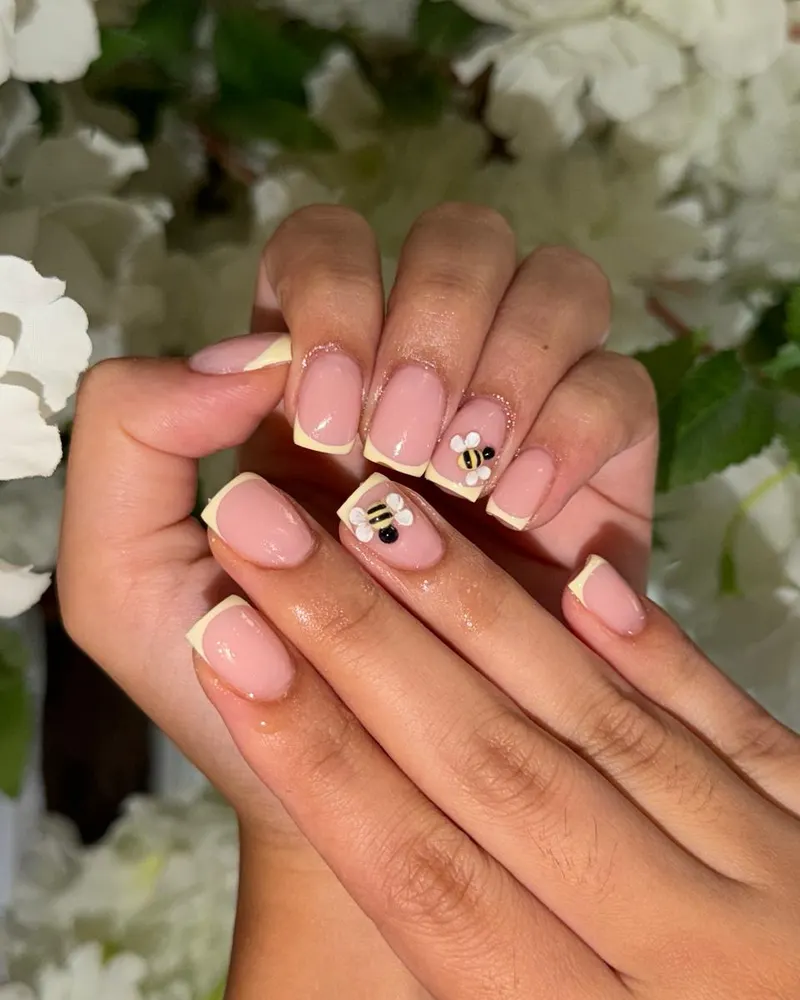 Milky nude nails with a bee accent